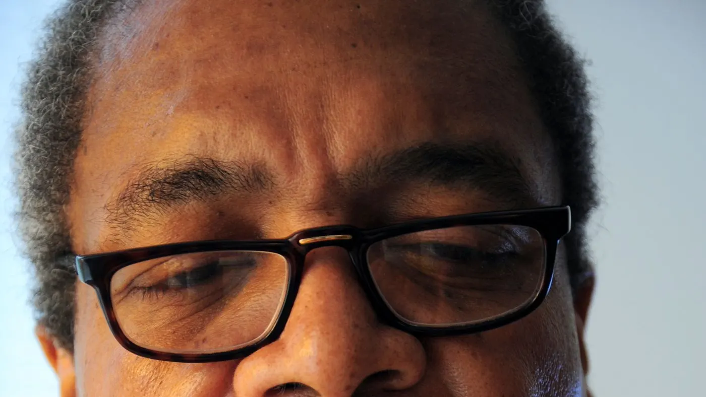 Primer plano de un hombre con gafas que baja la mirada para leer con atención: imagen para la comparación entre el sildenafil y el tadalafilo según sus prospectos